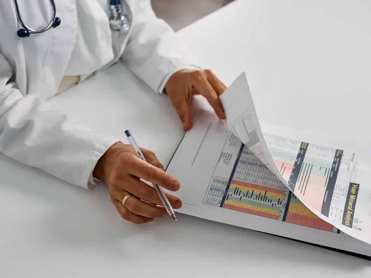 Profissional de saúde analisando documentos e exames — imagem ilustrativa.